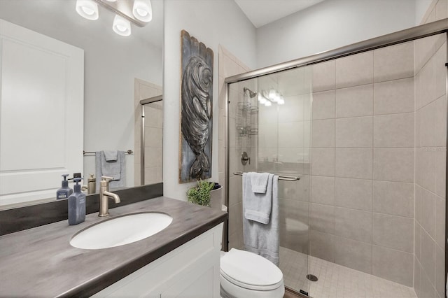 bathroom with vanity, toilet, and an enclosed shower