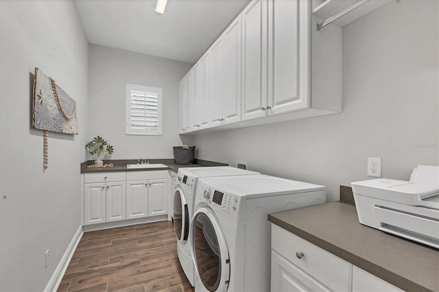 laundry area featuring dark hardwood / wood-style floors, cabinets, separate washer and dryer, and sink