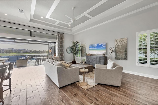 living room featuring ceiling fan, wood-type flooring, a high ceiling, and a tray ceiling