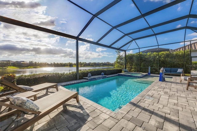 view of swimming pool with an in ground hot tub, a water view, glass enclosure, and a patio area