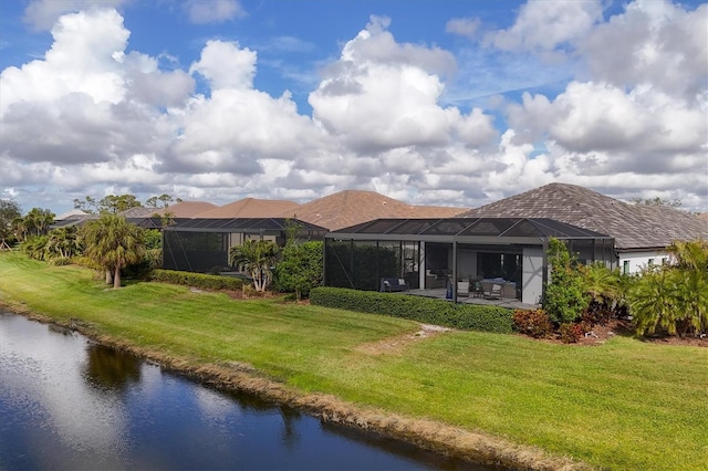 rear view of property with a patio area, a lanai, a yard, and a water view