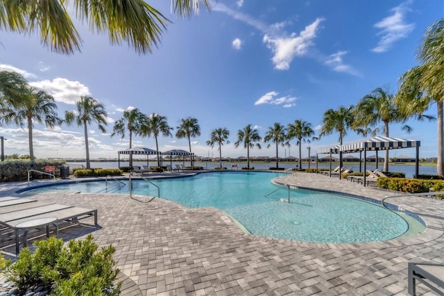 view of swimming pool featuring a patio area and a water view