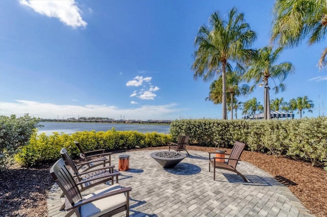 view of patio with a water view and a fire pit