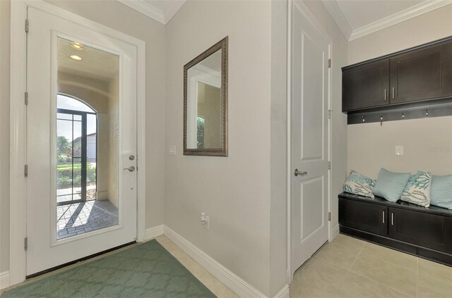 doorway to outside with light tile patterned floors and crown molding