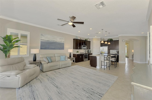 tiled living room featuring crown molding and ceiling fan