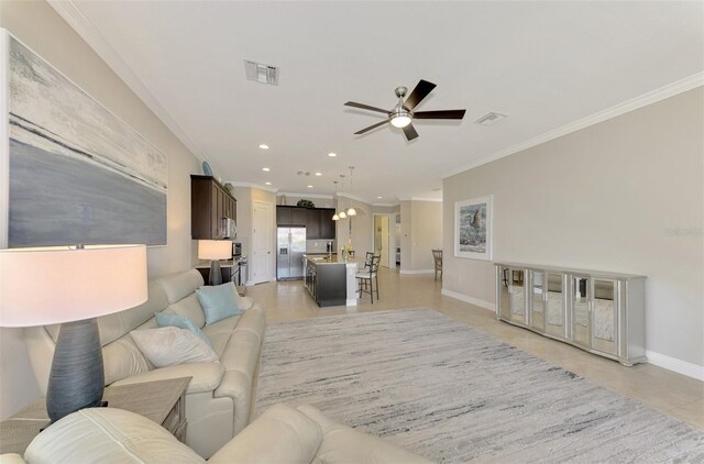 living room featuring ceiling fan, ornamental molding, and light tile patterned floors