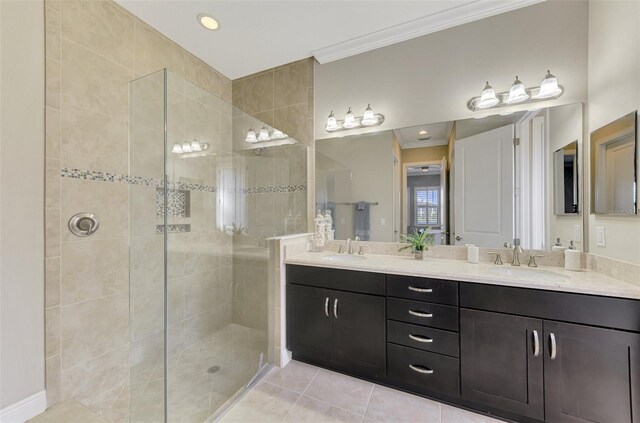 bathroom with a tile shower, tile patterned floors, vanity, and ornamental molding