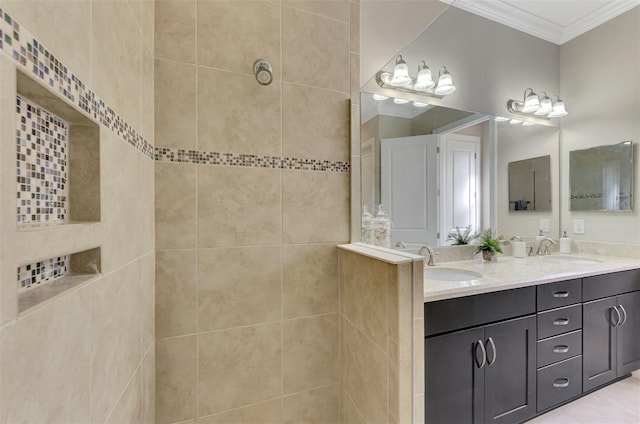 bathroom featuring tiled shower, vanity, and crown molding