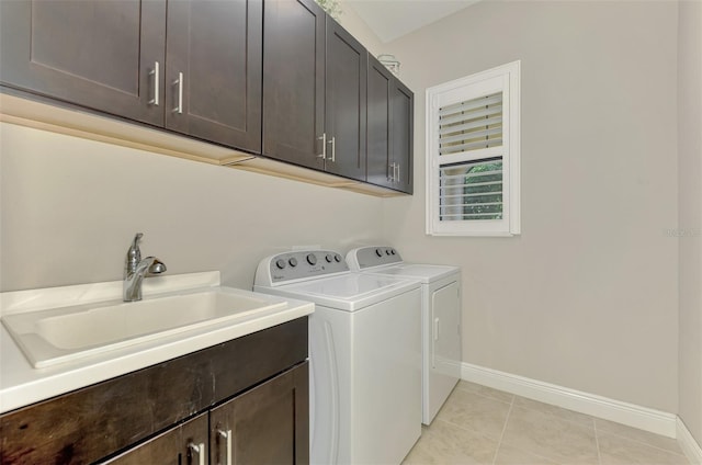 laundry area with cabinets, separate washer and dryer, light tile patterned flooring, and sink