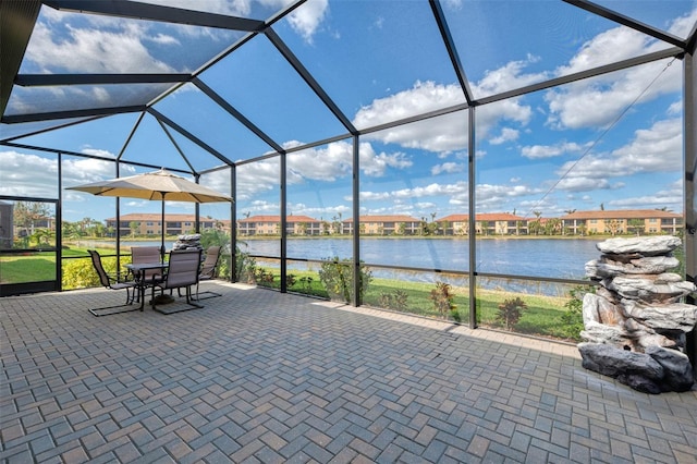 view of patio / terrace with a water view and glass enclosure