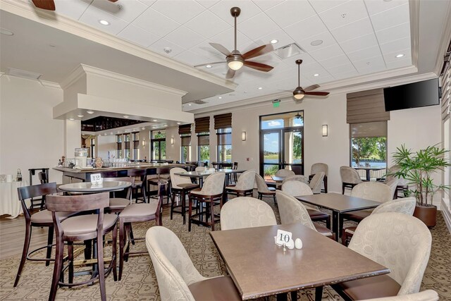 dining space with ceiling fan and ornamental molding