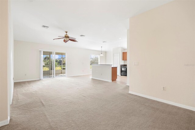 unfurnished living room with ceiling fan and light colored carpet