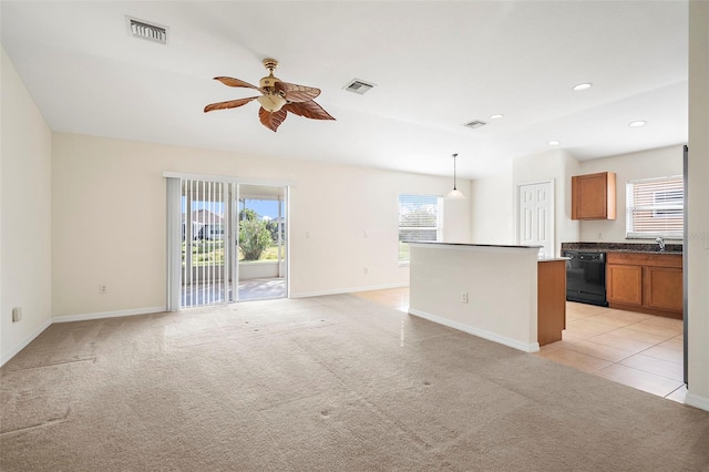 unfurnished living room featuring ceiling fan, sink, and light carpet