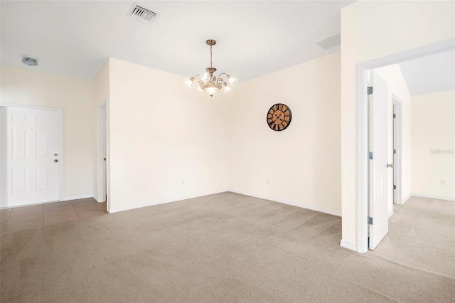 carpeted empty room with an inviting chandelier