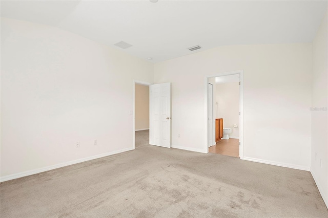 carpeted empty room with lofted ceiling