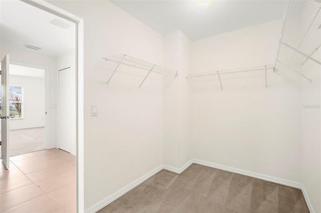 walk in closet featuring light colored carpet