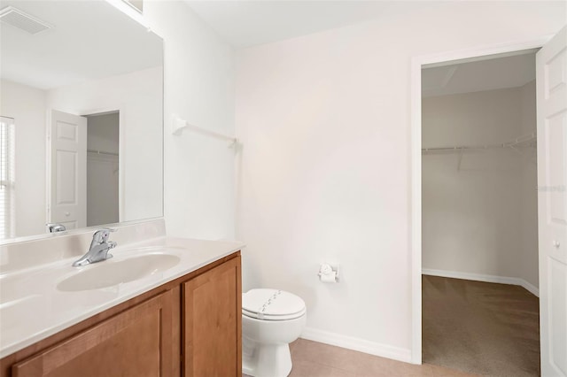 bathroom featuring tile patterned flooring, vanity, and toilet