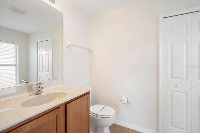 bathroom with tile patterned flooring, vanity, and toilet