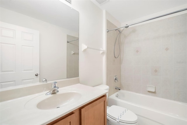 full bathroom featuring vanity, tiled shower / bath combo, and toilet