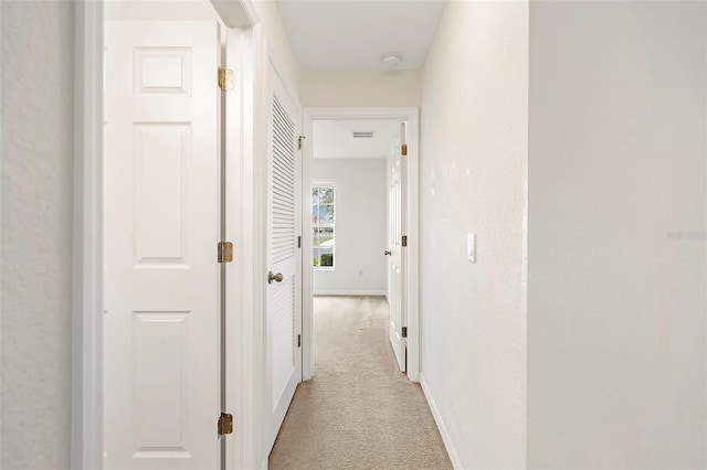 hallway with light colored carpet