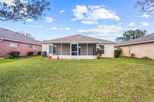 rear view of property with a sunroom, a yard, and central air condition unit