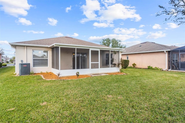 rear view of property featuring a sunroom, a lawn, and central AC