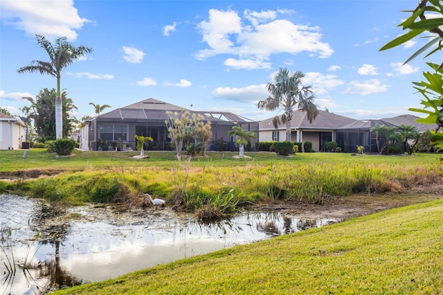 exterior space with a lanai, a yard, and a water view