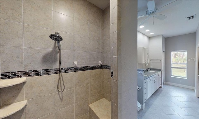 bathroom featuring ceiling fan, tile patterned flooring, vanity, and tiled shower