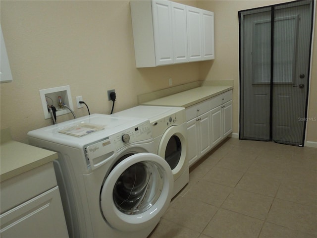 laundry room with cabinets, light tile patterned floors, and washer and dryer