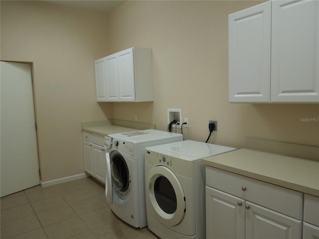 washroom with cabinets, light tile patterned floors, and washing machine and dryer