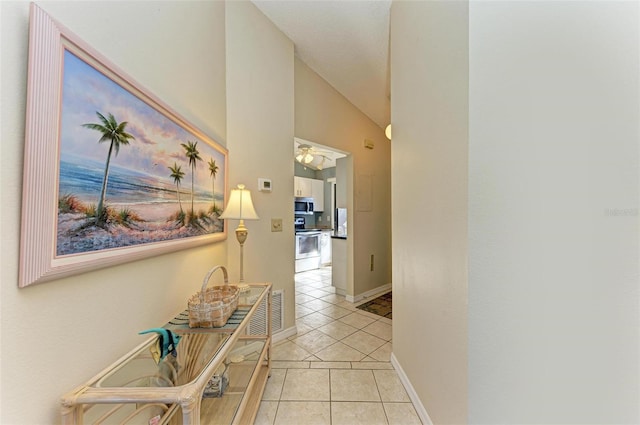 hallway with lofted ceiling and light tile patterned flooring