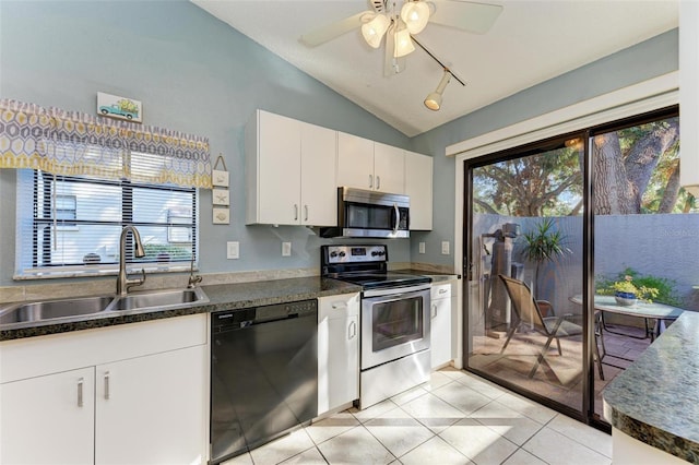 kitchen with sink, vaulted ceiling, light tile patterned floors, white cabinetry, and stainless steel appliances