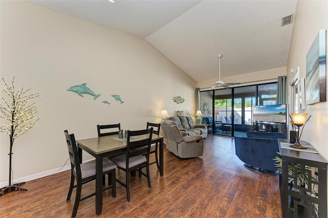 dining area featuring a textured ceiling, ceiling fan, dark wood-type flooring, and lofted ceiling