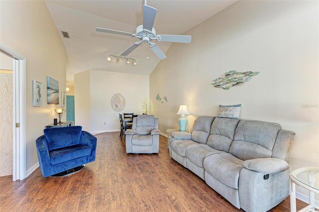 living room with ceiling fan, dark hardwood / wood-style flooring, and high vaulted ceiling