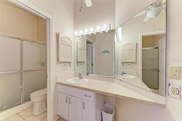 bathroom featuring tile patterned floors, vanity, a shower with door, ceiling fan, and toilet