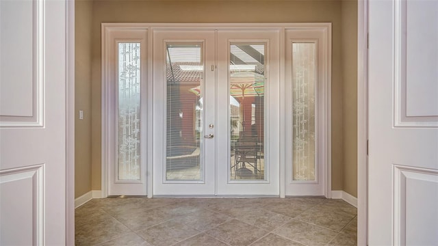 doorway to outside with french doors and light tile patterned flooring