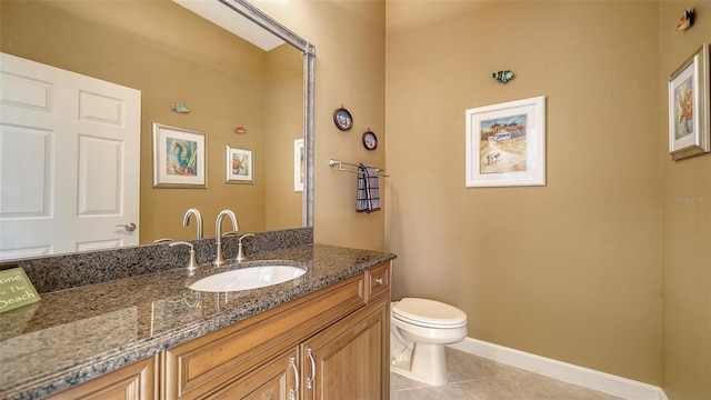 bathroom featuring tile patterned flooring, vanity, and toilet