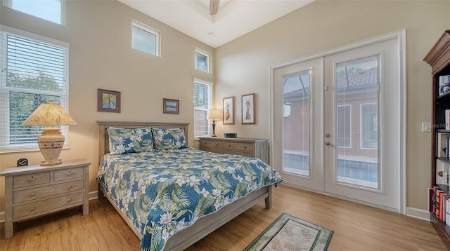 bedroom featuring ceiling fan, french doors, light hardwood / wood-style floors, lofted ceiling, and access to outside