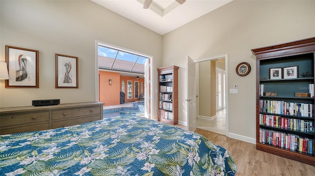 bedroom with high vaulted ceiling and light hardwood / wood-style flooring