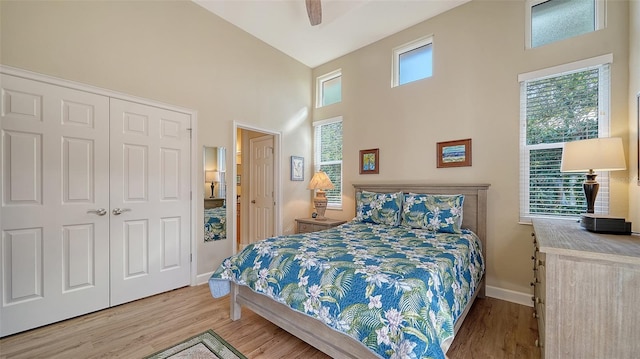 bedroom featuring ceiling fan, hardwood / wood-style floors, and high vaulted ceiling