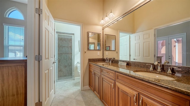 bathroom featuring tile patterned flooring, vanity, a shower with shower door, and french doors