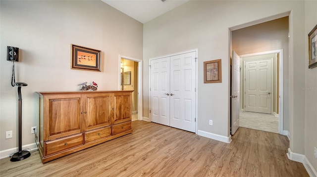 interior space with a towering ceiling and light hardwood / wood-style floors