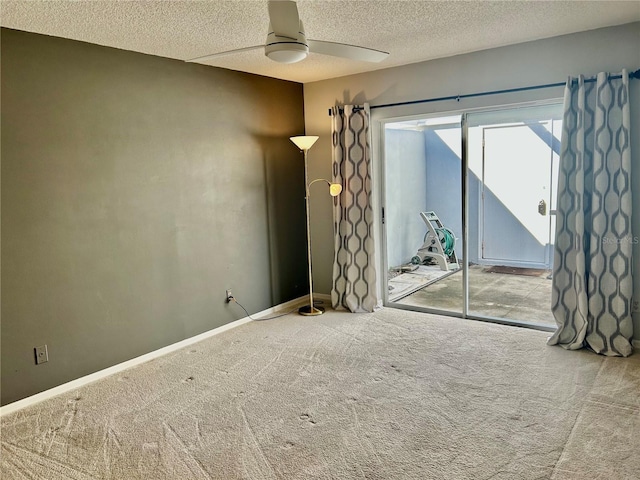 carpeted empty room with ceiling fan and a textured ceiling