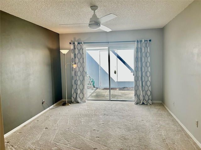 carpeted spare room with a textured ceiling and ceiling fan