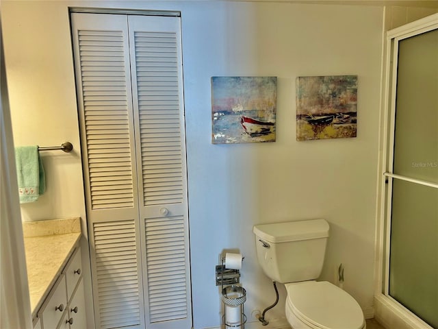 bathroom featuring vanity, toilet, and walk in shower