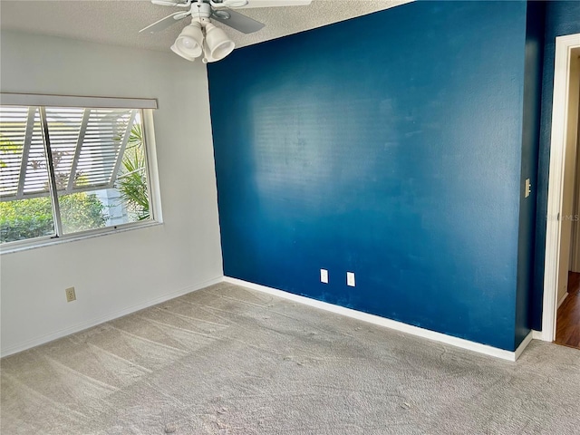 spare room featuring ceiling fan, a textured ceiling, and light carpet