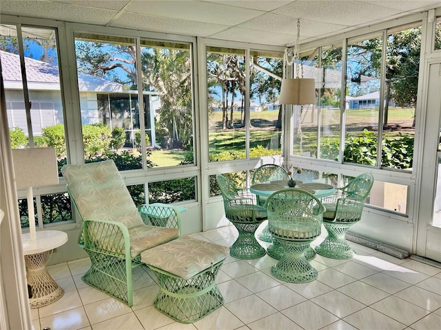 sunroom featuring a drop ceiling and a healthy amount of sunlight