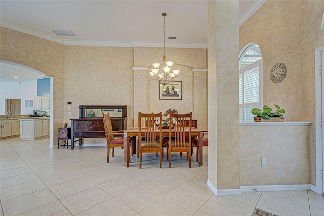 dining room with an inviting chandelier, light tile patterned floors, and crown molding