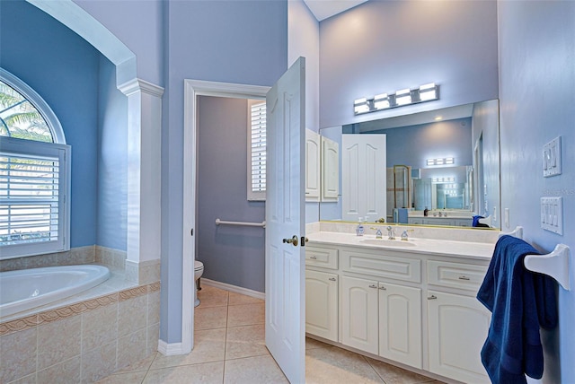 bathroom featuring a relaxing tiled tub, a wealth of natural light, tile patterned floors, and toilet