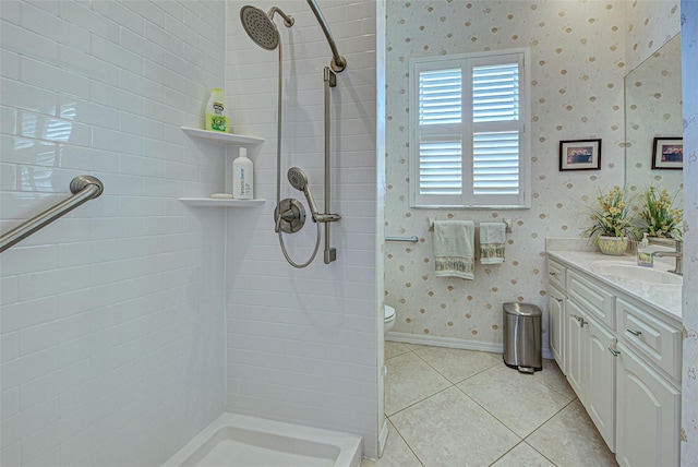 bathroom featuring toilet, tile patterned floors, tiled shower, and vanity